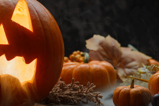 Glowing Traditional Carved Halloween Pumpkin With Fog and Autumn Decor