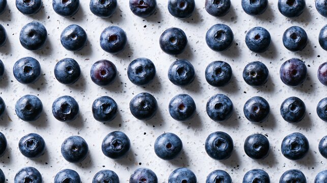 A geometric composition featuring blueberries arranged in perfectly aligned rows across pale terrazzo creating visual rhythm and balance
