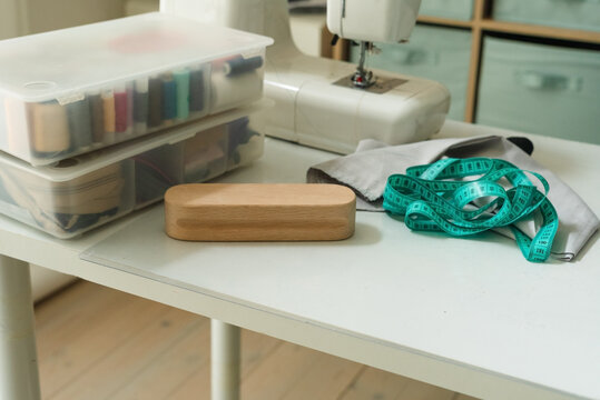 Pressing board for ironing seams and a sewing machine with fabric on a table for professional steam preparation. Tailor board used as a precise pressing tool in a home studio with natural light.