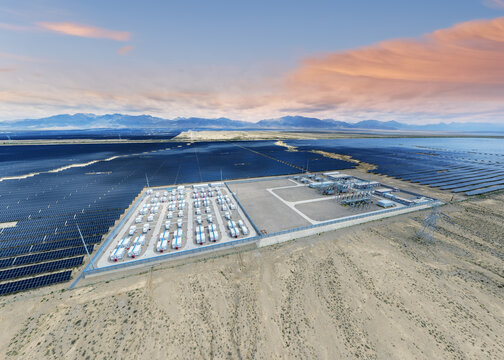 Aerial View of Energy Storage Power Station Amid Vast Solar Farm in Desert at Dusk