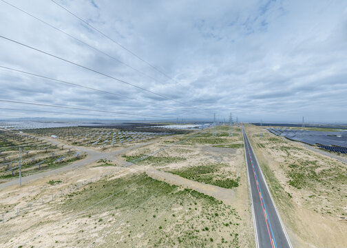 Aerial View of Straight Road Through Solar Farm and Energy Storage Power Station on Arid Grassland