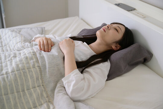 ベッドで昼寝をする20代日本人女性