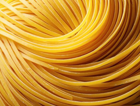 Close up of raw yellow pasta strands arranged in flowing spiral pattern. Dry long noodle shapes fill frame with golden curves. Food texture background shows uncooked wheat grain product for italian
