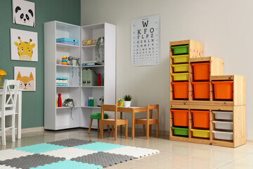 Obraz premium Interior of pediatricians office with table, shelf unit and toys