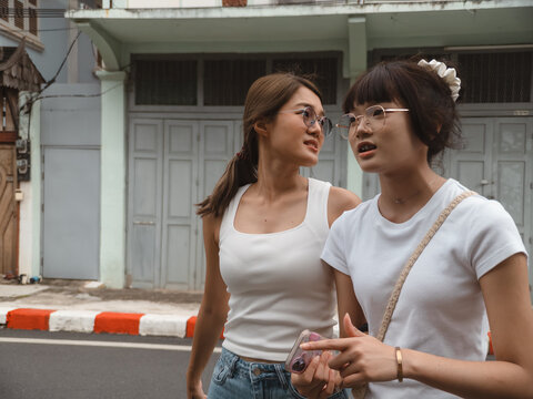 Friends exploring an old town street, casually chatting while enjoying their day out.