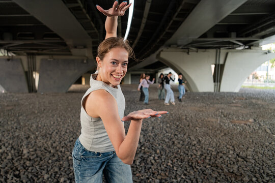 Happy young woman dancing under a city overpass