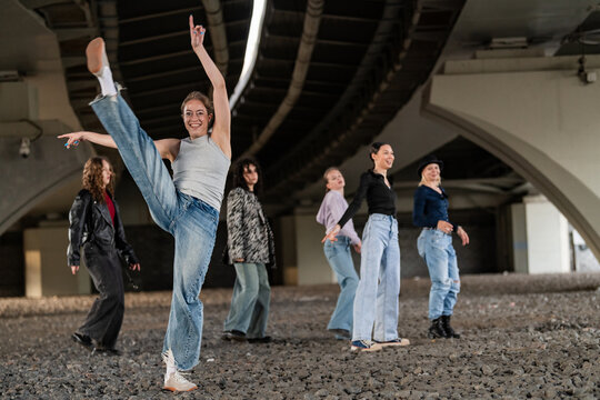 Energetic woman high kicking with her dance crew