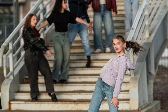Young girl posing with her dance crew on stairs