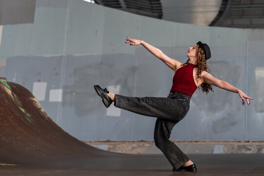 Stylish woman dancing in an urban skatepark