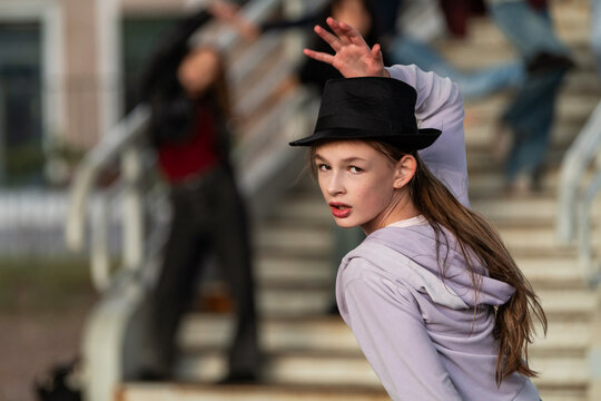 Teen girl in top hat striking a pose outdoors