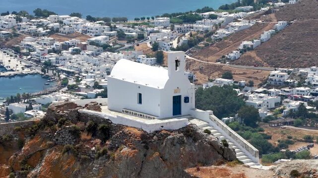Close-up aerial view of the church of Agios Konstantinos at the main town Chora of Serifos island with the harbour of Livadi in the background, Cyclades, Greece