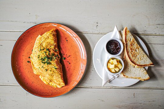 Omelette and toast breakfast on a rustic wooden table