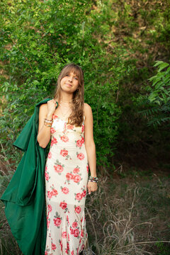 Young woman graduate in a floral dress outdoors