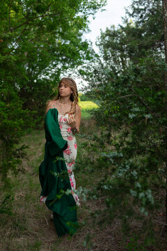 Thoughtful young graduate walks through a forest