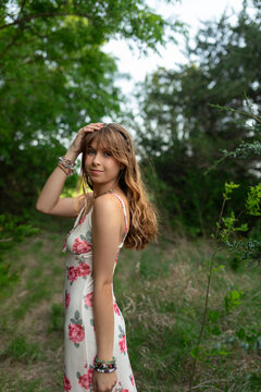 Young woman in a floral dress posing in a forest