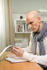 Portrait of middle aged man managing household expenses with utility bills Checking shopping receipts carefully before updating household expense records and monthly budget © Denys Kurbatov