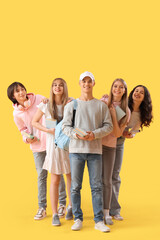Obraz premium Group of students with books on yellow background