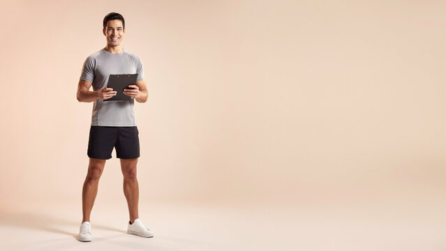 A fit young man in athletic sportswear stands holding a black clipboard, looking at the ad social media download thambnail poster web template event festival 2026 2027 2028