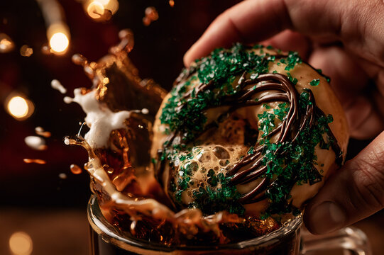 St. Patrick's Day Irish cream glazed donut being dunked into dark coffee
