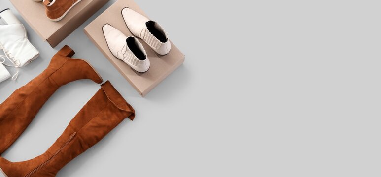 Fashionable women's footwear collection with brown suede boots, white ankle boots, and beige chelsea boots on cardboard boxes