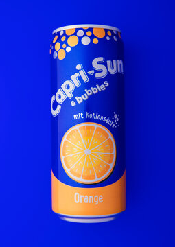 LONDON,UK - DECEMBER 16, 2025: Original Capri Sun orange soda soft drink juice on blue background.
