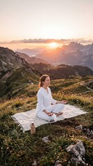 Fototapeta premium A serene woman in white clothing practices yoga on a mountain peak during a golden sunset hour.