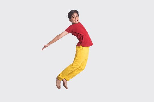Portrait of a happy young boy jumping in the air in excitement (Children)  