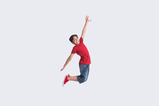 Portrait of a happy young boy jumping in the air in excitement (Children)  