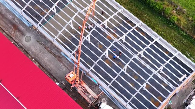 Aerial view of concrete pump pouring slab at construction site