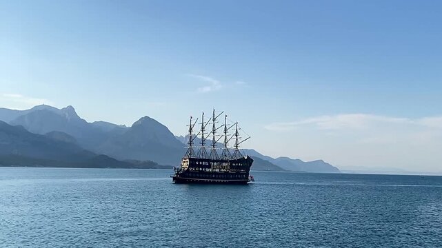 View of the Taurus Mountain range and the Mediterranean Sea in Kemer, Turkey. A lonely ship on the background of a seascape. Blue water. In the open sea.	