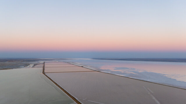 Aerial View of Vast Salt Flats Reflecting Pastel Sky

