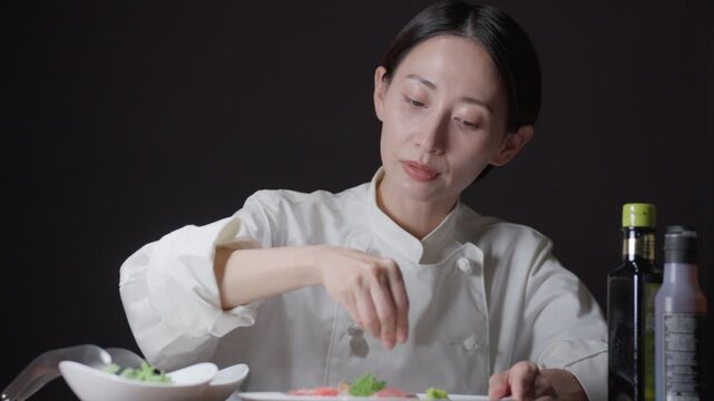 料理の盛り付けをする女性シェフ