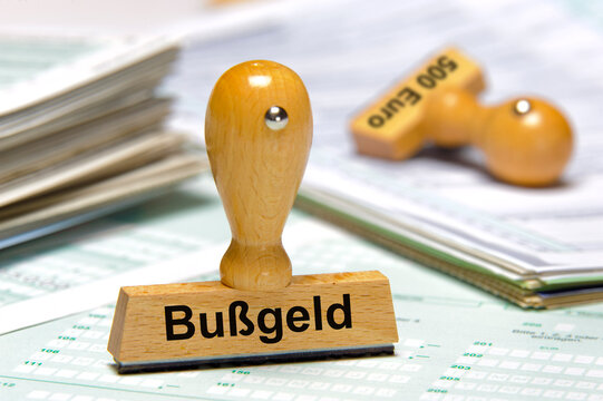 Ein Holzstempel ist beschriftet mit dem Aufdruck: Bu&szlig;geld