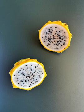 Half a yellow dragon fruit on a gray background. Close-up. Top view.