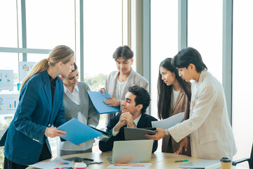 Fototapeta premium Business leader discussing priorities colleagues while managing multiple reports urgent tasks. Office communication, workload balancing, leadership and project coordination under deadline pressure.
