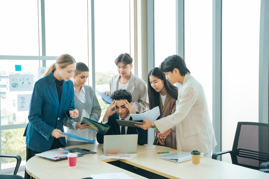 Stressed business professional surrounded team members requesting updates decisions. Office deadline pressure, multitasking, workload management workplace stress during   intense corporate meeting.