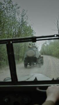 View from a car of a Soviet armored vehicle on a forest road