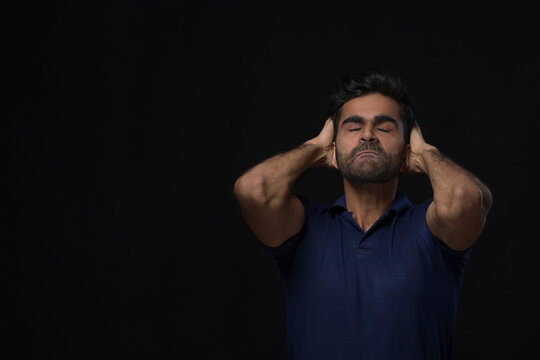 midshot of an angry man holding his head