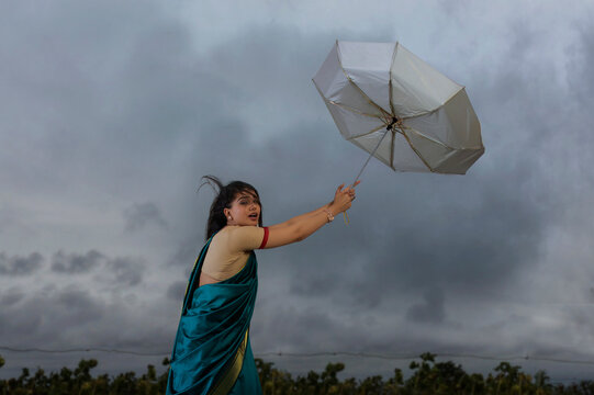 woman trying to hold on the umbrella in bad weather