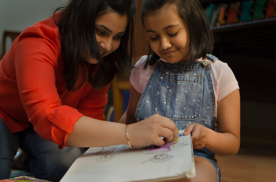 Mother helping her daughter in drawing