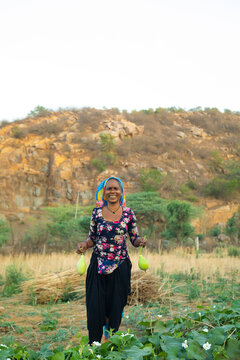 woman holding bottle gourd and smiling,in the field