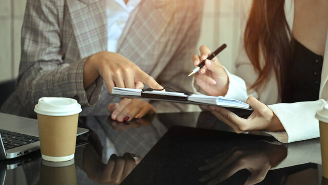 Businesspeople in formalwear reviewing a contract or important paperwork at office