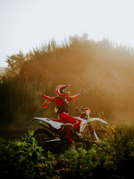 Motocross rider celebrating on a white bike at golden hour