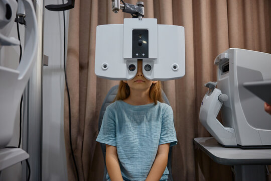 A girl seated calmly during comprehensive eye evaluation with specialized