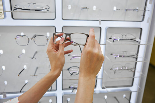 Eyewear selection process, individuals hands holding glasses