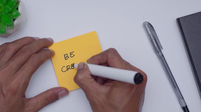 A man is writing the words Be Creative that illustrating to be productive or creative