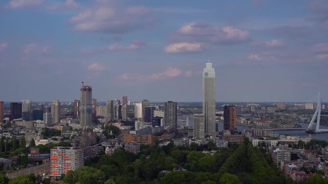 Panoramica skyline view of Rotterdam cityscape featuring the tall Zalmhaven tower and Erasmus Bridge, observed from the Euromast observation tower in the Netherlands.