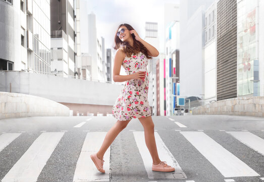 Young woman crossing road on zebra crossing