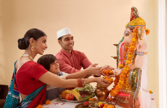Family offering flowers to Ganpati Idol on Ganesh Chaturthi