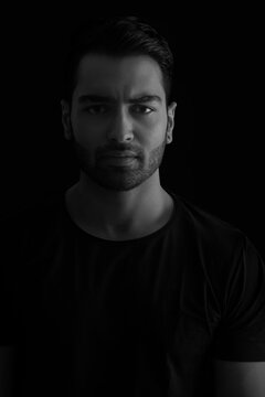 Portrait of a young man standing in the darkness